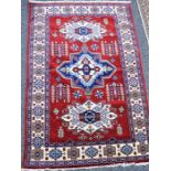 A Kazakhstan rug. central field red background with three medallions and multiple borders 155cm x