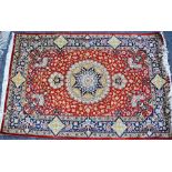 A Persian Qum (Ghom) hand knotted silk pile rug. central field red with central medallion and