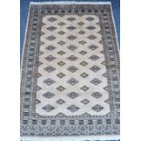 A Persian Qum (Ghom) hand knotted wool/silk pile rug. a cream and brown geometric central field with