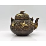 A Chinese bronze teapot, of squat form with handle, the sides with mythical birds and a tortoise