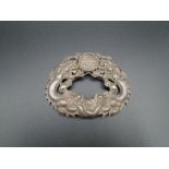A Chinese white metal belt/shoe buckle depicting traditional dragons 10cm at longest point