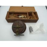 Vintage wooden fishing reel with brass fixings and a box of homemade lures