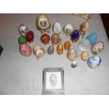 A collection of decorative eggs, some marble, china, glass and pewter