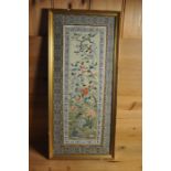 a silk panel stitchwork framed depicting flowers butterflies, dragon-fly and foliage, needle work
