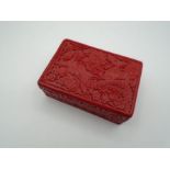 A red oriental design resin lidded box 13 cm long by 9cm wide 5 cm high.