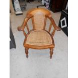 An early 19th century hoop backed Bergere library chair with split cane panel seat