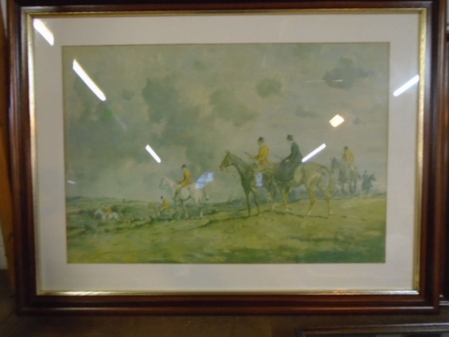 A framed print of a fox hunting scene