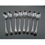 A set of 8 silver spoons with crossed guns design on each, all hallmarked 110gms