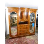 Edwardian flame mahogany and inlaid triple wardrobe compactum armoire raised on a plinth base with