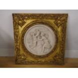 A guilt framed plaque depicting women with a cherub