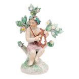 A Plymouth figure of a putto: playing a lyre and seated on a tree stump mound base with flowering