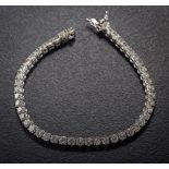 An 18ct white gold and 8ct diamond line tennis bracelet: with forty-eight circular brilliant-cut