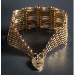 A 9ct gold ten bar, gate-link bracelet: with heart-shaped padlock clasp and safety chain,