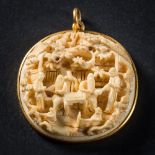 A late 19th Century Cantonese carved ivory low relief pendant: depicting figures in a woodland