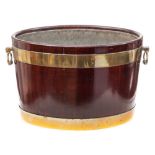 A George III mahogany and brass bound oval wine cooler: of coopered construction with zinc liner