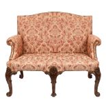 An 18th Century and later carved walnut settee:, with an arched upholstered stuff over back,