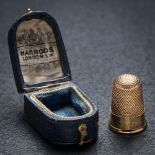 A Victorian gold thimble 'Xmas 1891' in Harrods case: the thimble without holes and in good