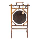 A brass circular gong on a bamboo stand:, with carrying handle on angled dual end splayed legs, 59.