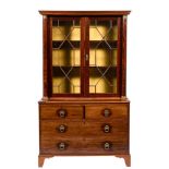 A 19th Century French mahogany bookcase:, the upper part with an overhanging moulded cornice,