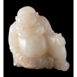 A Chinese jade carving of Budai: the stone of pale celadon colour with white and russet inclusions