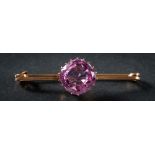 A pink topaz single-stone bar brooch: the cushion-shaped pink topaz approximately 12mm long x 12mm