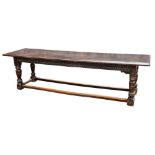 An oak refectory table:, the well patinated single plank top on turned legs,