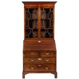 A George III mahogany bureau bookcase:, the later upper part with a moulded dentil cornice,