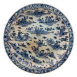 A Safavid pottery dish: of shallow circular form decorated in underglaze blue with rocks and