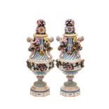 A pair of Dresden neo-classical urns and covers: each of spiral fluted form applied with putti and