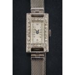A lady's diamond mounted cocktail wristwatch: the rectangular dial with Arabic numerals and blued