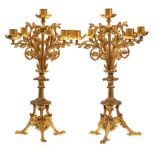 A pair of late Victorian gilt metal four-branch candelabra: with plain cylindrical nozzles on swept