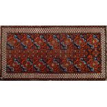 A Belouchistan rug:, the field with a design of brick red and indigo geometric patterned squares,