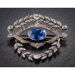 A sapphire and diamond brooch: with central shaped oval sapphire approximately 11mm long x 7.