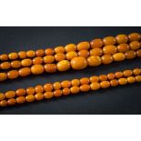 A graduated amber bead three-string necklace: with oblong beads graduated from approximately 9mm to