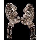 A pair of Art Deco diamond ear clips: each with an open work scroll design mille-grain-set with