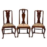 A set of four George II mahogany dining chairs: the curved backs with shaped toprails and pierced