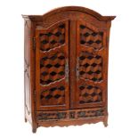 A miniature armoire: with arched moulded cornice and incised frieze,
