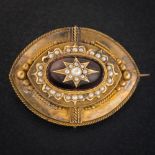 A Victorian cabochon garnet and seed pearl mounted oval pendant/brooch: the reverse with glazed
