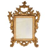 A 19th Century Continental carved giltwood mirror:, with open cartouche cresting with flowerhead,