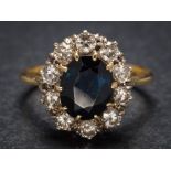 A sapphire and diamond oval cluster ring: the central oval sapphire approximately 10mm long x 8mm