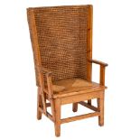 An Orkney Islands pine wing armchair:, with a curved ropework back and slip in seat,