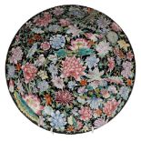 A Chinese famille noire millefleurs charger: painted with lotus, peony,