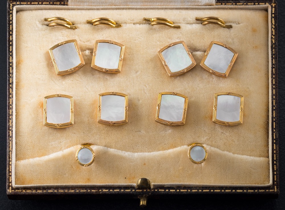 A cased set of mother-of-pearl mounted cuff-links and dress studs: stamped '9ct'.