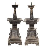 A pair of Chinese cast bronze bronze pricket candlesticks: of archaic design,