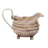 A late Georgian silver cream jug, all marks worn: crested,