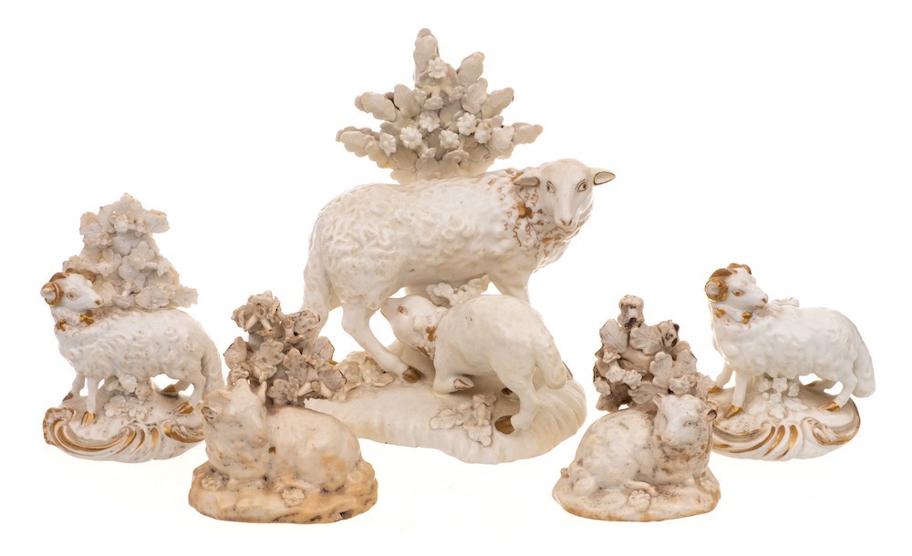A group of five Derby and other white and gilt porcelain models of sheep: the largest of a ewe