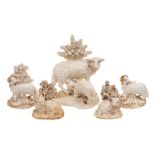 A group of five Derby and other white and gilt porcelain models of sheep: the largest of a ewe