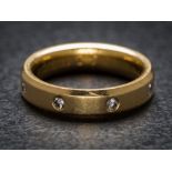 An 18ct gold and diamond four-stone band: set with round brilliant-cut diamonds,