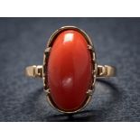 A 9ct gold and oval coral single-stone ring: the oval coral approximately 17mm long x 9mm wide
