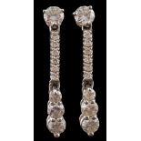 A pair of hallmarked 18ct white gold and diamond drop earrings: each set with a single round